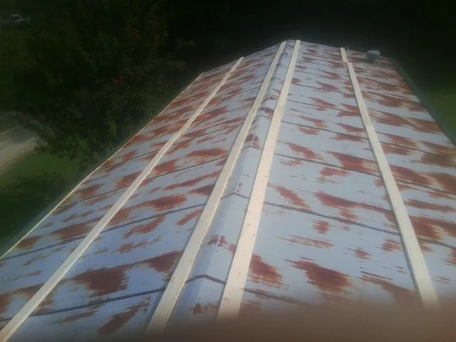 Rusted metal roof panels with new wood purlins before replacement — Storm Damage Roof Repair in Calabash by Roofing Brothers