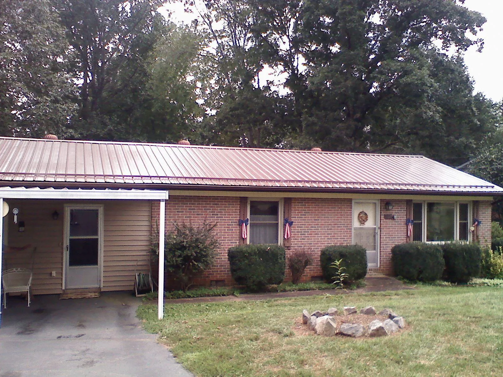 Bronze metal roof and carport on a brick ranch home — Roof Repair work by our crew in Calabash
