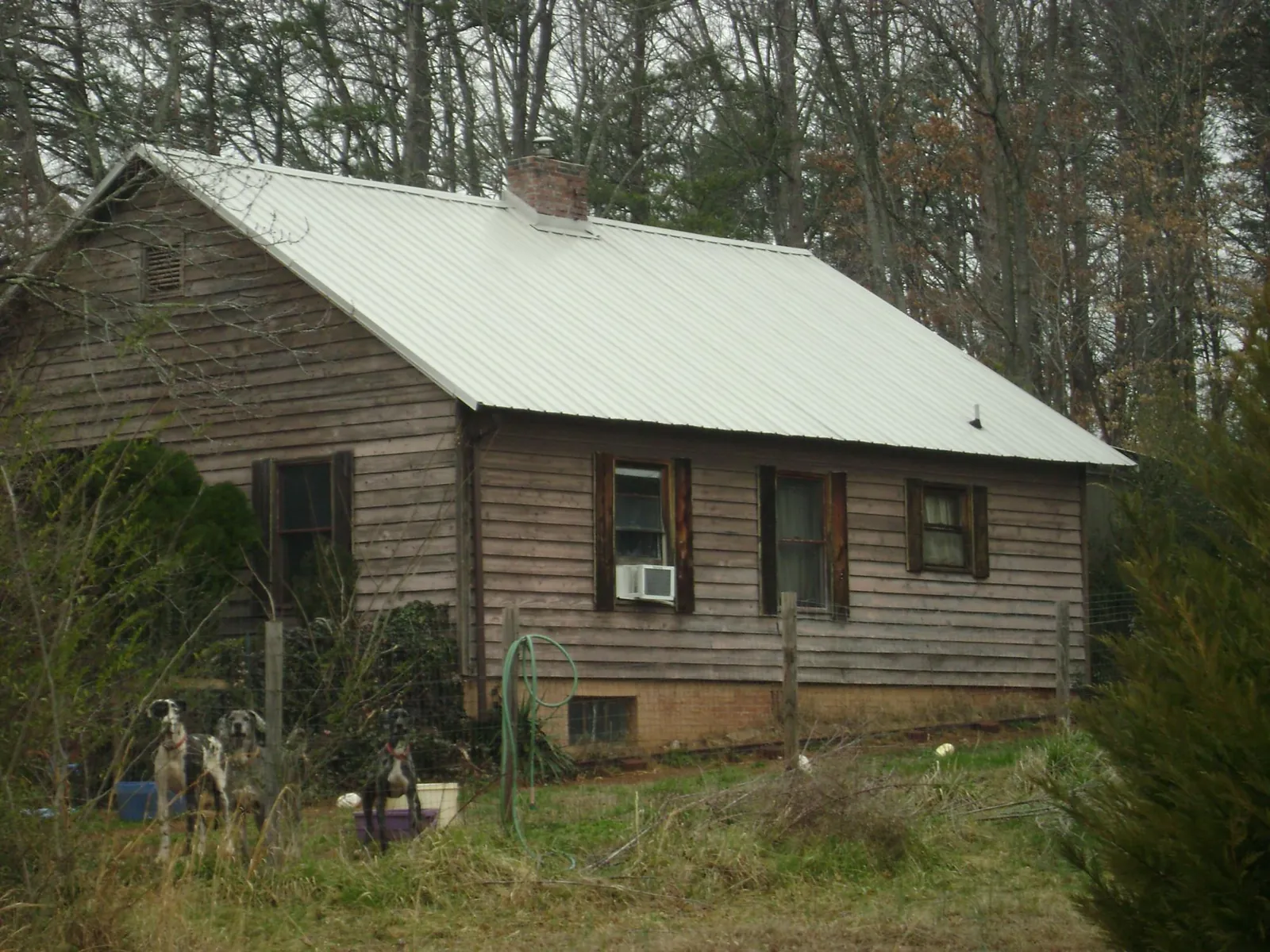 White metal roof on an old wood sided farmhouse, from a Metal Roof Installation job in Calabash